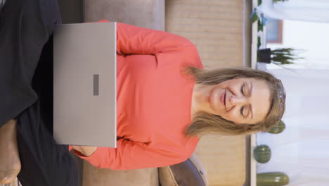 Vertikales-Video-Einer-Frau,-Die-Mit-Glücklichem-Gesichtsausdruck-Am-Laptop-Arbeitet.